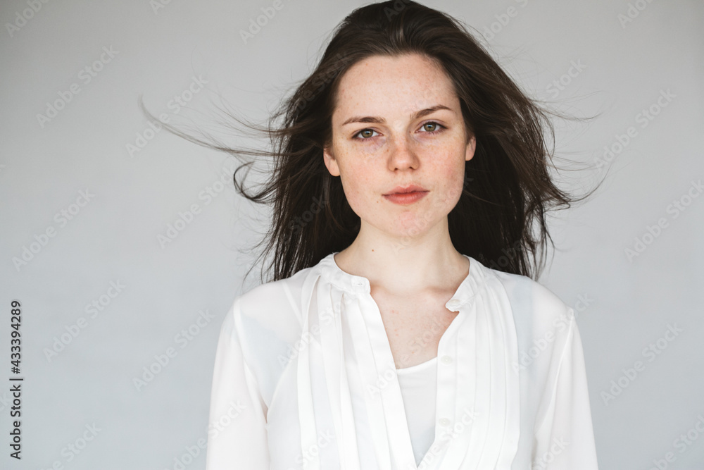 Young beautiful woman freckles face beaty natural healthy skin smile over gray Young beautiful woman freckles face beaty natural healthy skin smile over gray