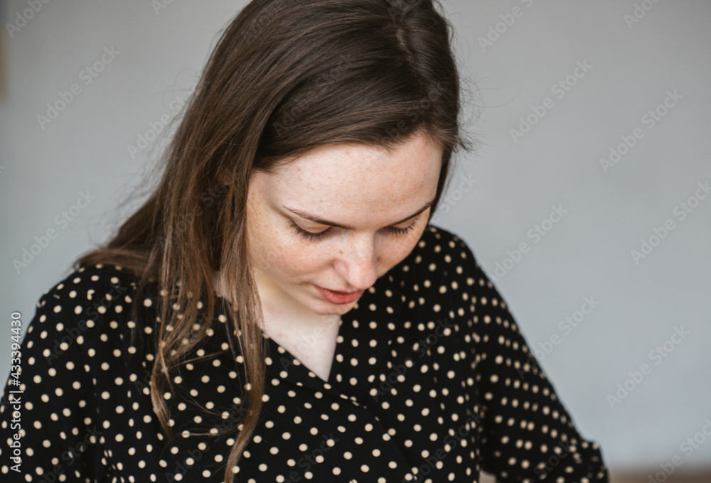 Young beautiful woman in polka dot dress freckleds face over gray background beauty Young beautiful woman in polka dot dress freckleds face over gray background beauty