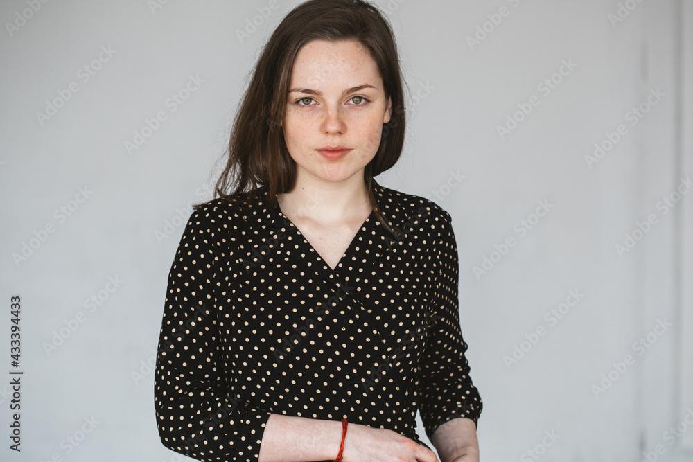 Young beautiful woman in polka dot dress freckleds face over gray background beauty Young beautiful woman in polka dot dress freckleds face over gray background beauty