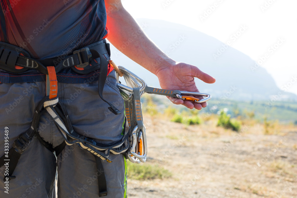 Climbing equipment on a male climber: rock shoes, rope, quickdraw