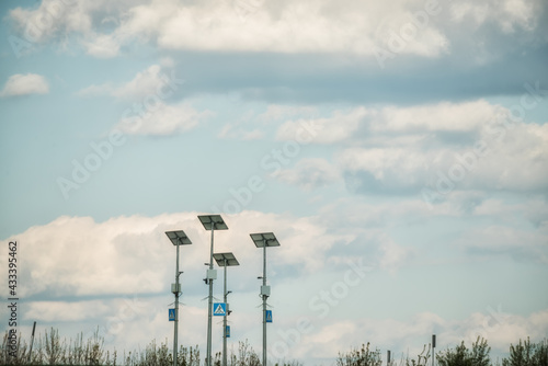 Solar panels and road signs on the background of the sky with clouds. Selective focus.