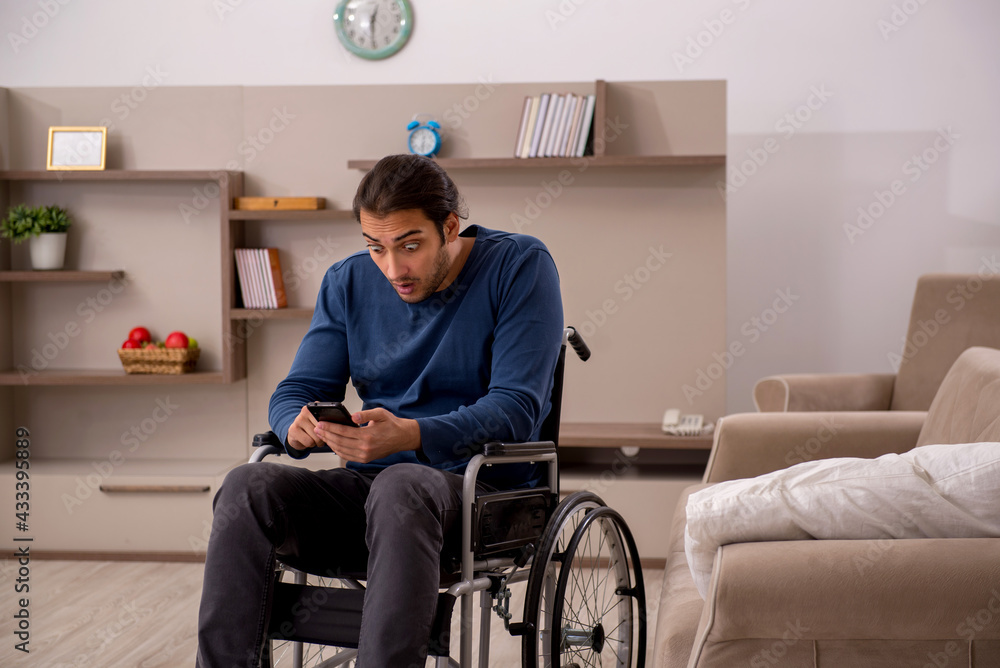 Young man in wheel-chair suffering at home