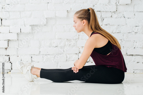 Woman stretching sport training at home over brick wall