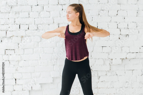 Woman stretching sport  training at home over brick wall