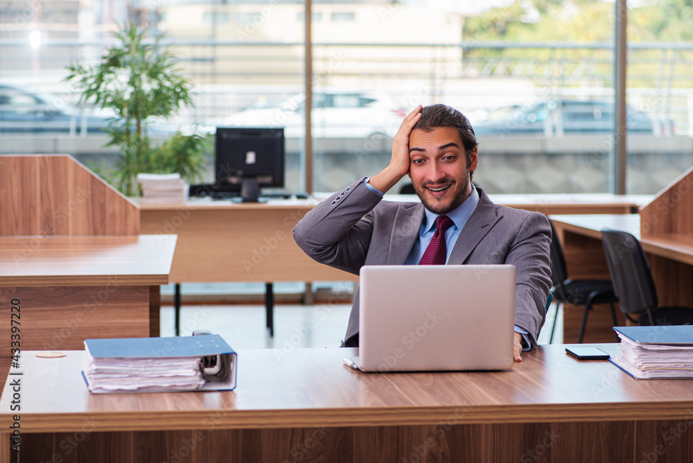 Fototapeta premium Young male employee working in the office