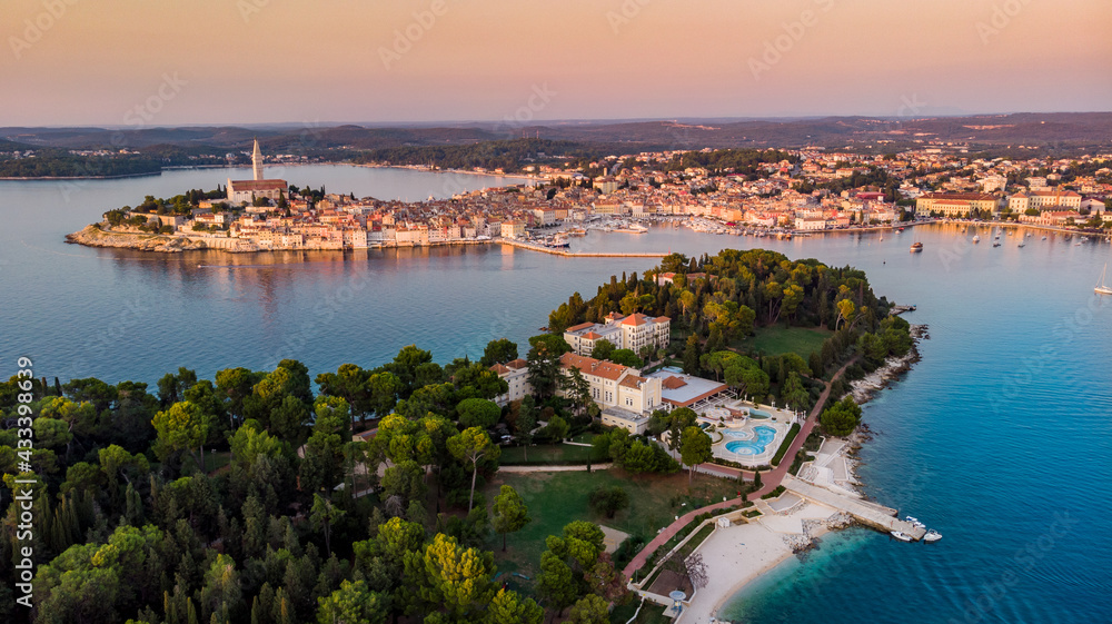 Aerial view of Istrian Town Rovinj, Croatia at the sunset. Sveta Katarina Island is visible in the foreground with a hotel and swimming pool.