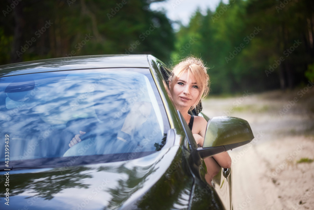 Smiling young woman driving a car.