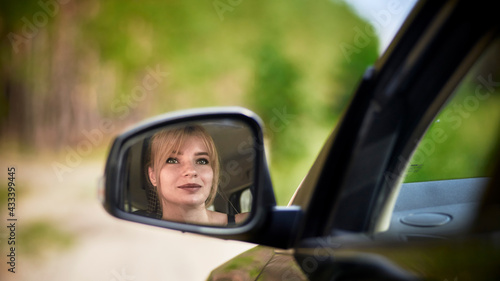 Reflection of woman in rear-view mirror © Nikamata
