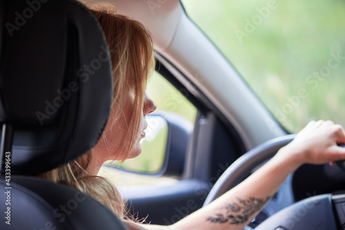 Blond woman driving a car automobile interior hands on wheel