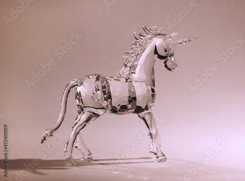 Glass Chrystal unicorn on light purple pink background.