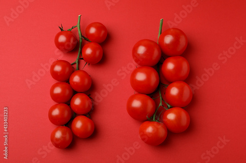 Fresh cherry tomato branches on red background © Atlas