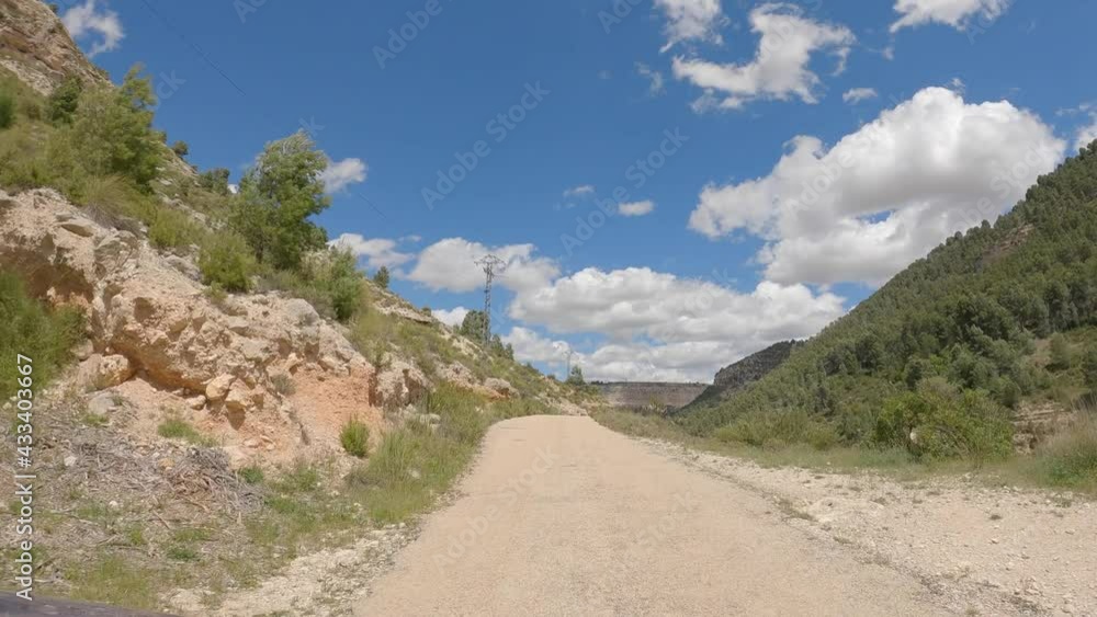 Car Mount Point of View. Driving through a narrow mountain road on sunny day. Canyon Jucar. Albacete, Spain. Car Mount Point of View. Driving through a narrow mountain road on sunny day. Canyon Jucar. Albacete, Spain.