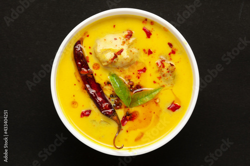 Close-up of Indian traditional kadhi or kadi pakora yogurt and gram flour and turmeric served hot in a bowl. Over black background.
 photo