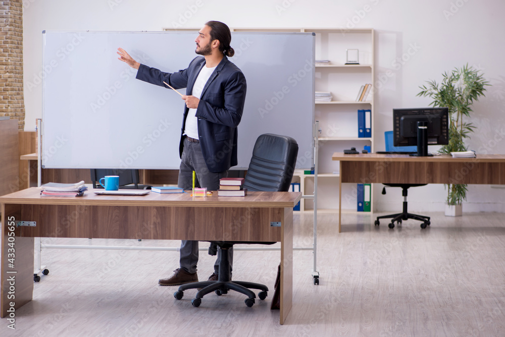 Young male teacher in the classroom Young male teacher in the classroom