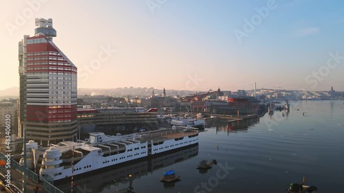 Tram Travelling At Gotaalvbron Bridge With P-Arken Ship On Harbour Beside Lilla Bommen Building At Sunrise In Gothenburg, Sweden. - aerial