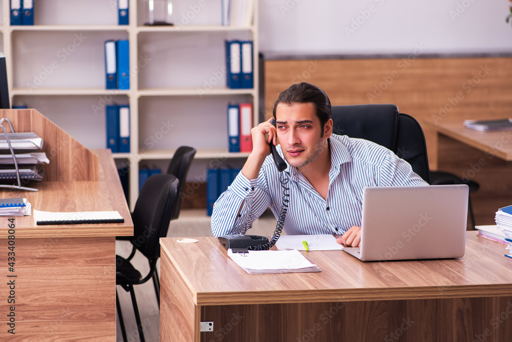 Young male employee working in the office Young male employee working in the office