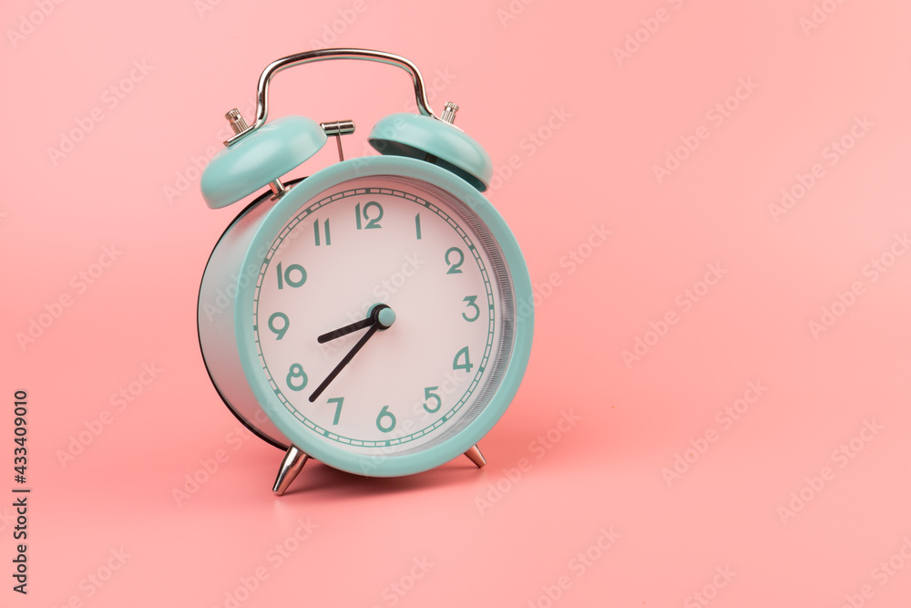 Old clock isolated on a pink background with space for text. Concept of time Old clock isolated on a pink background with space for text. Concept of time