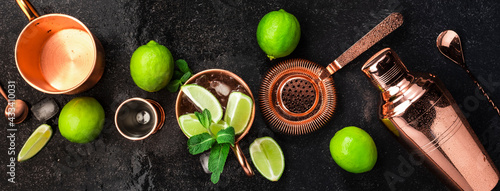 Moscow Mule. Preparation cocktail with ginger beer, vodka, lime and ice. Copper bar tools. Black bar counter. Top view