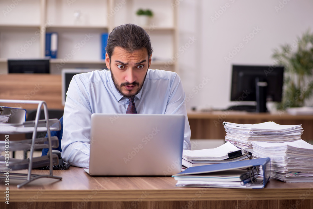 Young businessman employee unhappy with excessive work in the of Young businessman employee unhappy with excessive work in the of