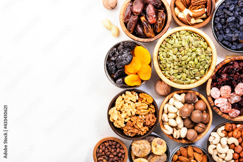 Nuts and dried fruits. Dried apricots, figs, raisins, pecans, walnuts, hazelnuts, almonds and other. White background, top view Nuts and dried fruits. Dried apricots, figs, raisins, pecans, walnuts, hazelnuts, almonds and other. White background, top view