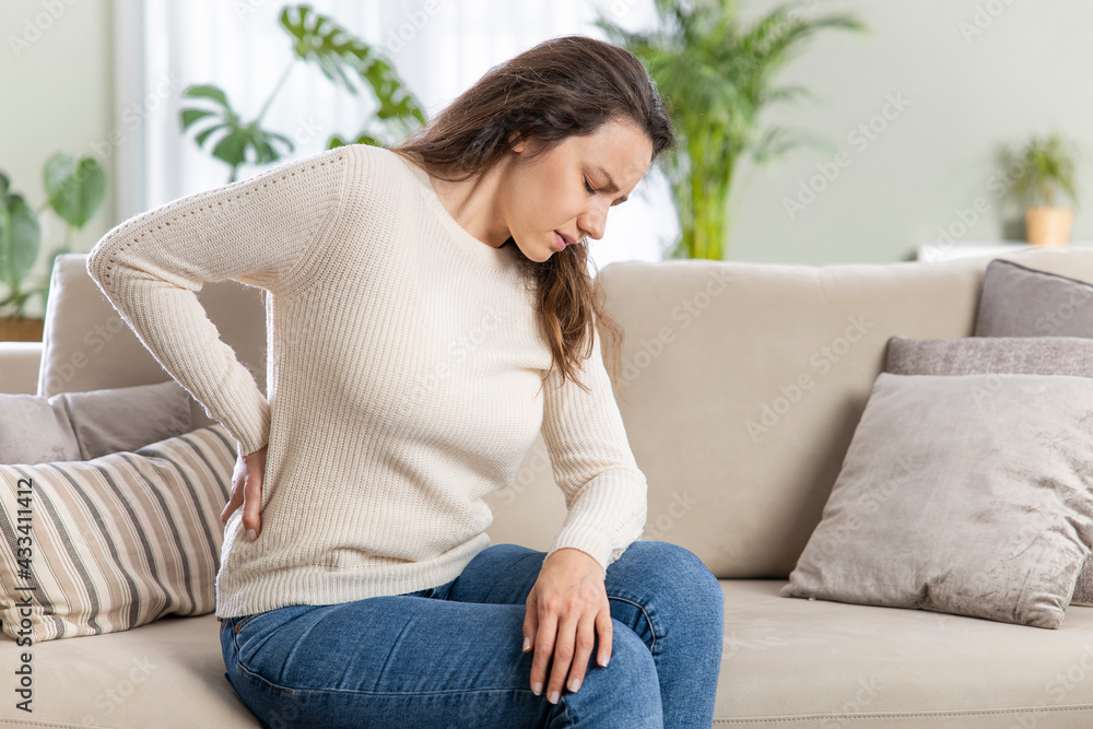 Fototapeta premium Young woman suffering with back pain.