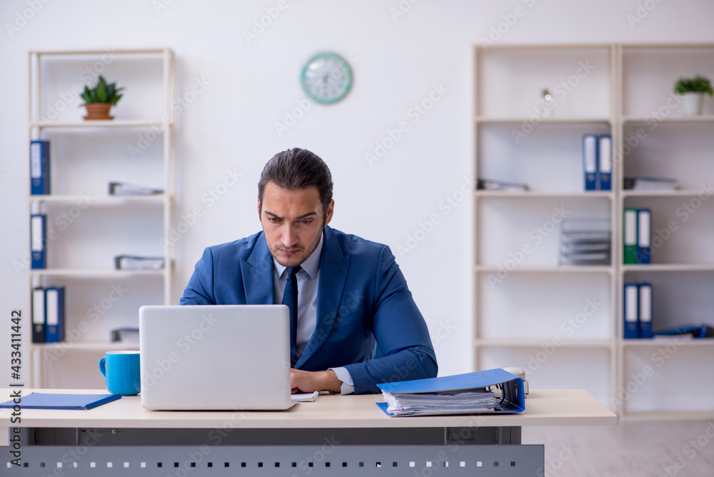 Young male employee working at workplace Young male employee working at workplace