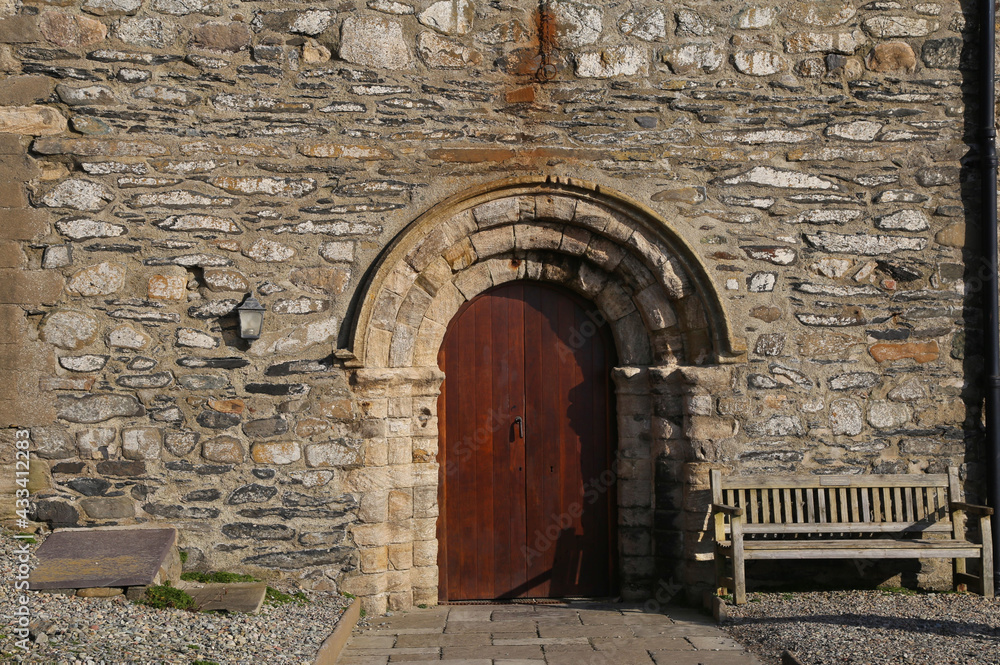 Fototapeta premium A Norman doorway which is the entrance to St Hywyn's Church, an ancient building in Aberdaron, Gwynedd, Wales, UK.