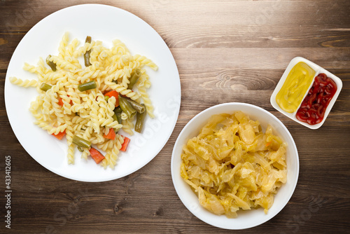 pasta with green beans with garlicand carrots on a white plate on a wooden background. Mediterranean Kitchen . photo