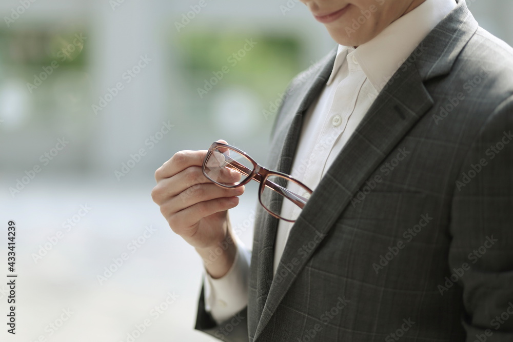Close up of businessman holding eyeglasses