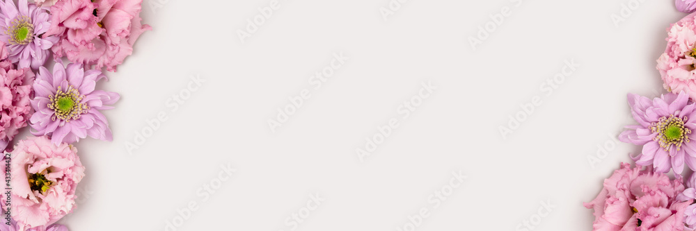 Banner with frame made of eustoma and aster flowers texture on a gray background. Floral concept with copyspace. Banner with frame made of eustoma and aster flowers texture on a gray background. Floral concept with copyspace.