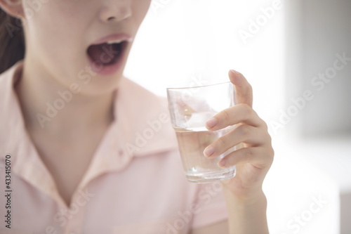Close up of young woman drinking glass of water