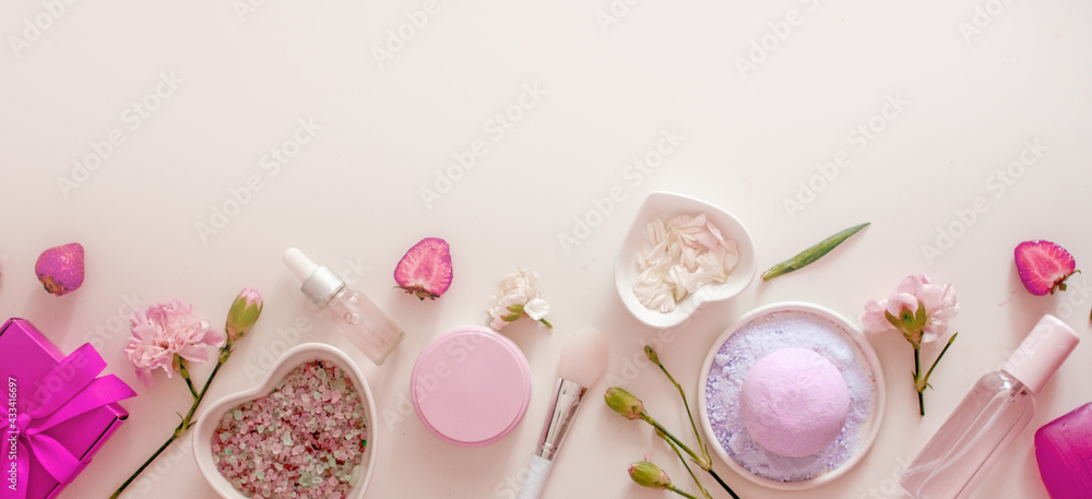 Plakat Natural cosmetics with floral scent on a pink background banner. Bath salt, aromatic bomb, oils, cream, serum, flower petals, top view, flat lay, copy space. Floral cosmetics background