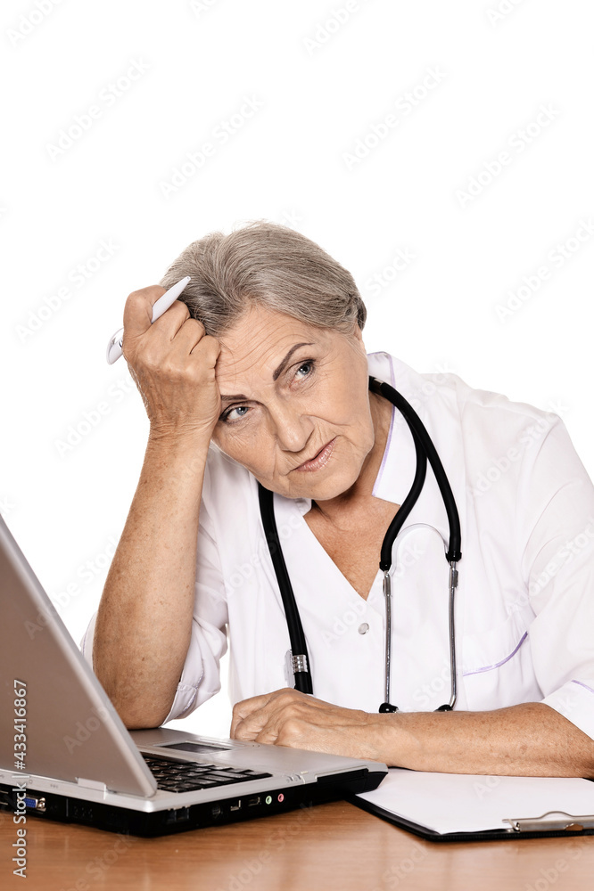 Confident female doctor sitting at table with laptop Confident female doctor sitting at table with laptop