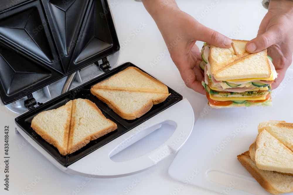 sandwich toaster toast bread slice hand fry hold biscuit cheese morning