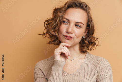 Young ginger thinking woman smiling and looking aside