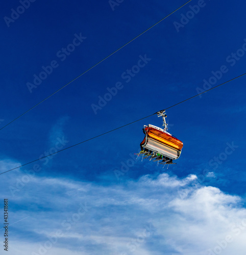 TIROL, AUSTRIA - FEBRUAR 16th, 2020: skiers in bright ski suits taking chair lift up the mountain photo