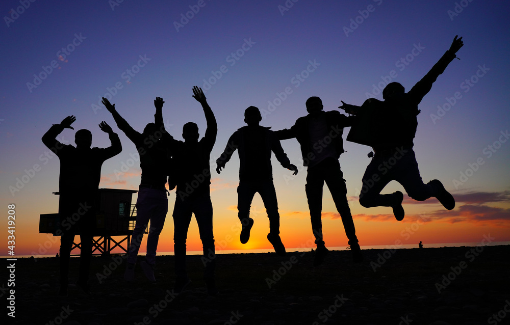 people jumping on the background of the sunset