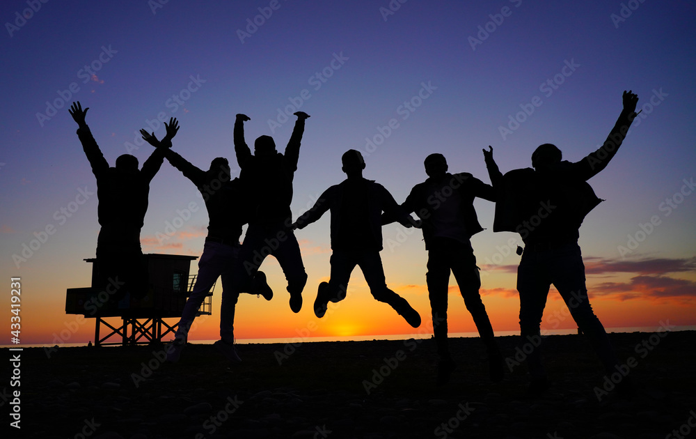 people jumping on the background of the sunset
