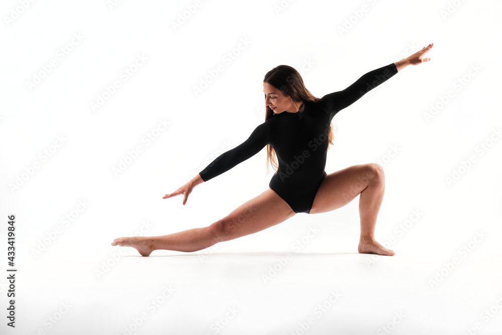 Fitness girl with long hair doing stretching and fitness poses with a black body isolated in a white background