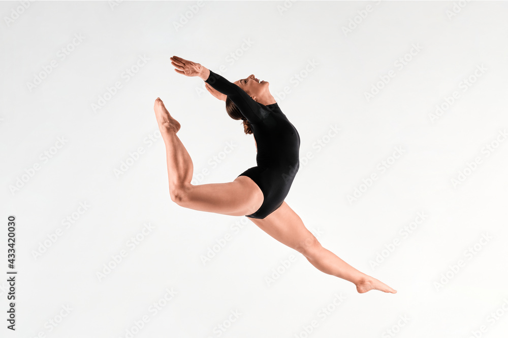 Fitness girl with long hair doing stretching and fitness poses with a black body isolated in a white background