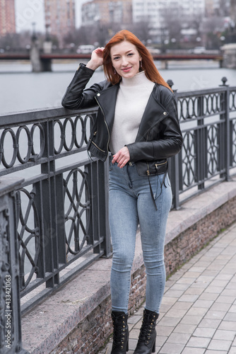 Portrait of a beautiful and positive redhead woman with clothes in grunge style. Posing while walking © Павел Костенко