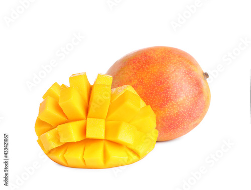 Delicious whole and cut mangoes on white background