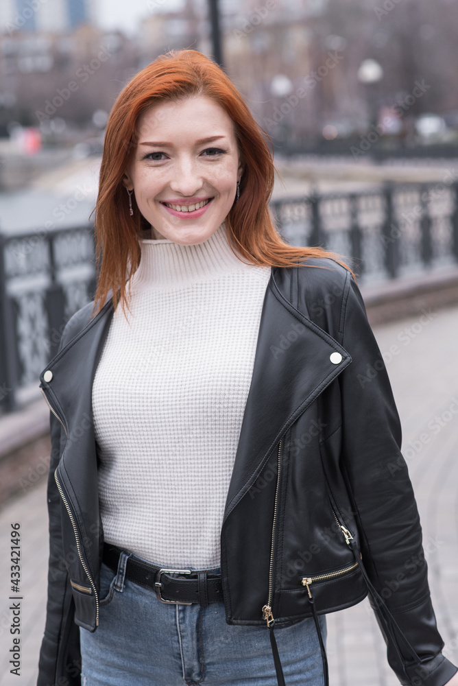 Portrait of a beautiful and positive redhead woman with clothes in grunge style. Posing while walking Portrait of a beautiful and positive redhead woman with clothes in grunge style. Posing while walking