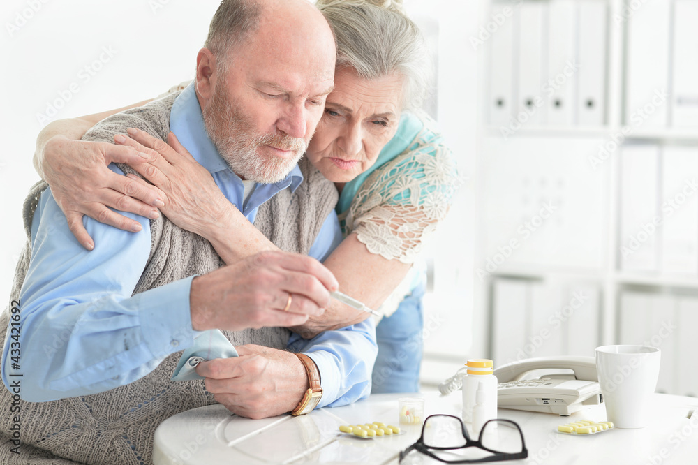Obraz premium ill Senior couple with thermometer at home