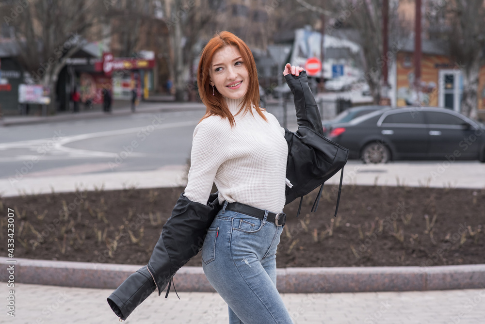 Portrait of a beautiful and positive redhead woman with clothes in grunge style. Posing while walking Portrait of a beautiful and positive redhead woman with clothes in grunge style. Posing while walking