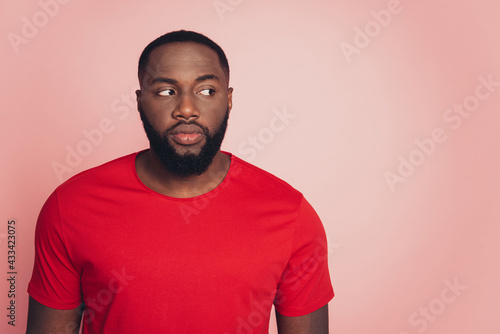 Serious young african man look empty space isolated over pink background