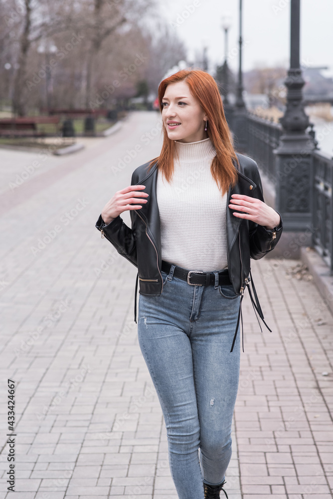 Portrait of a beautiful and positive redhead woman with clothes in grunge style. Posing while walking Portrait of a beautiful and positive redhead woman with clothes in grunge style. Posing while walking