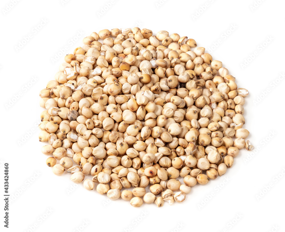 pile of raw unhulled Sorghum grains on white pile of raw unhulled Sorghum grains on white