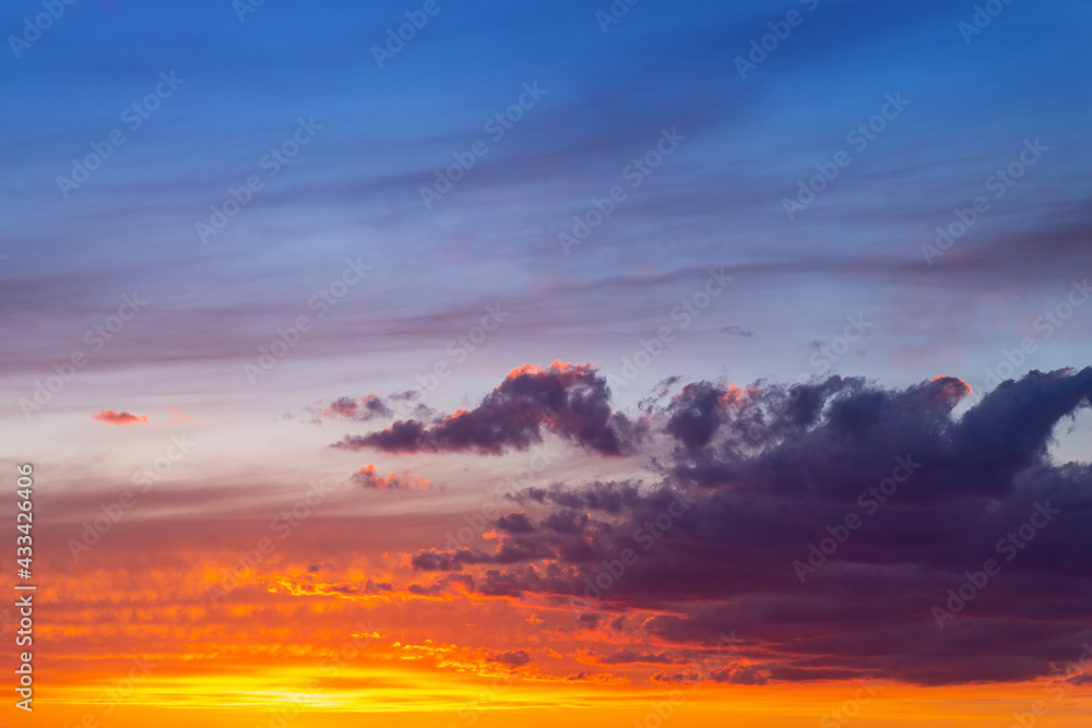 Dramatic colorful red orange to dark blue sunset or sunrise sky landscape clouds. Natural beautiful cloudscape dawn background wallpaper. Stormy windy nature twilight dusk scene panorama