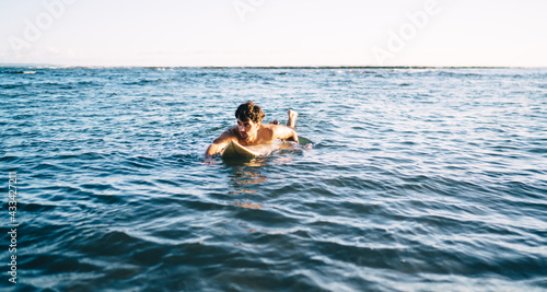Strong surfer on surfboard floating on seawater © BullRun
